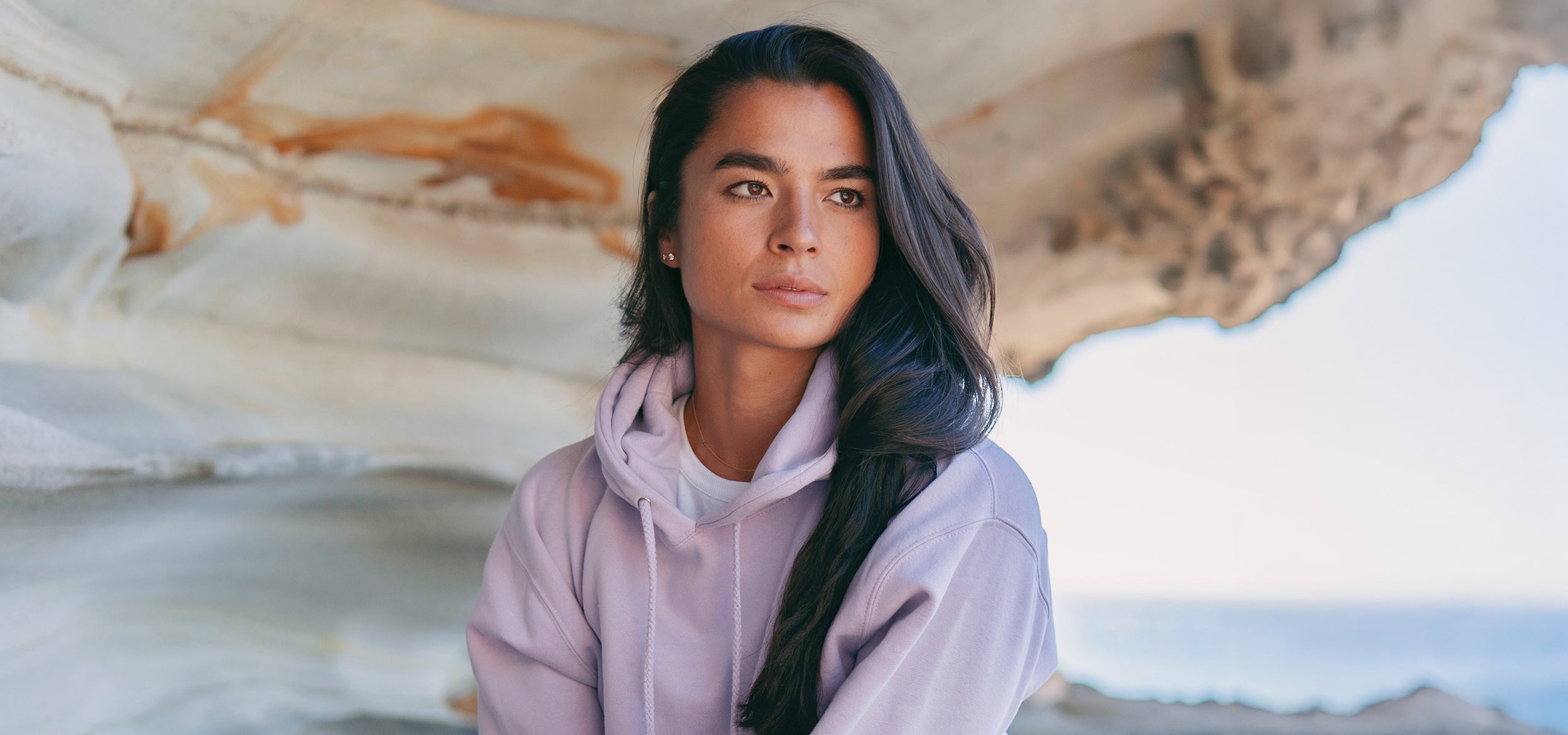 woman wearing a lavender color hoodie at the beach