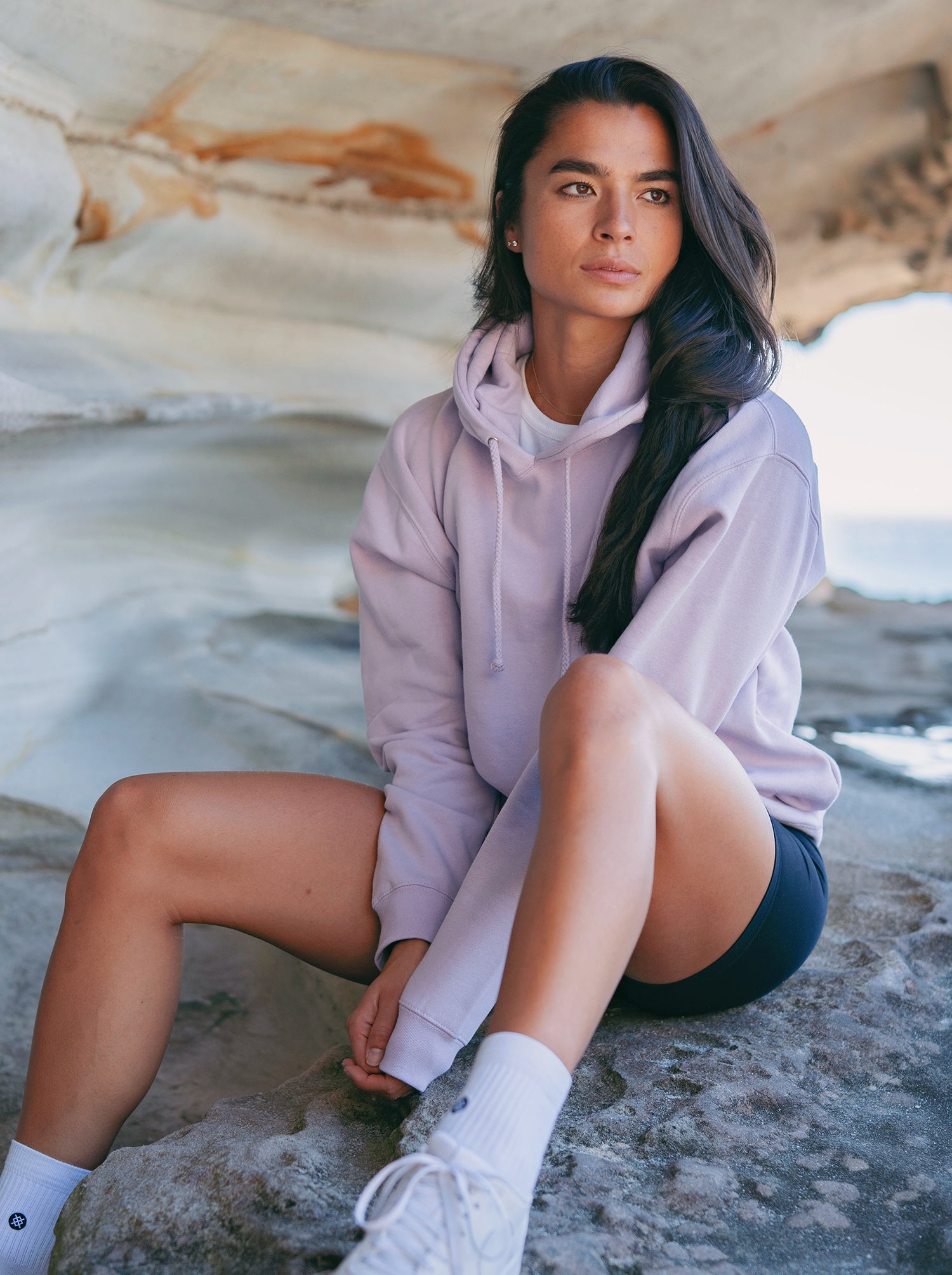woman wearing a lavender color hoodie at the beach